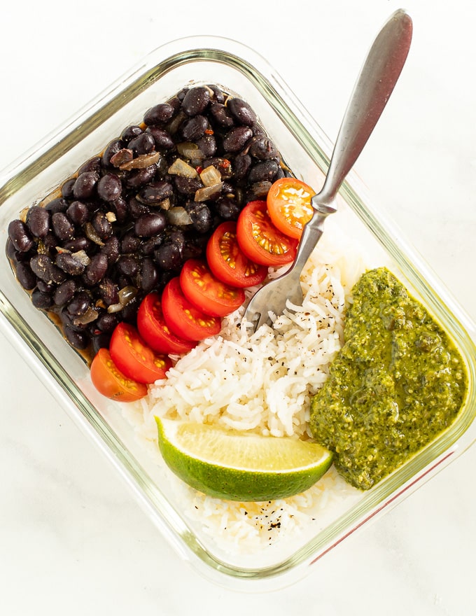 a vegan meal prep container of black beans and rice with a fork