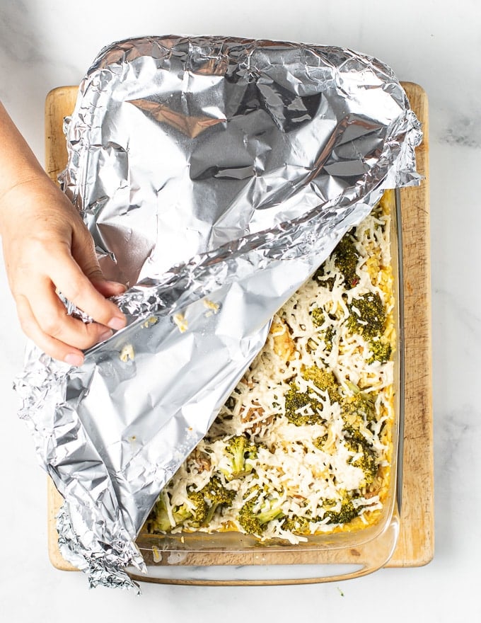 foil being removed from vegan broccoli rice casserole