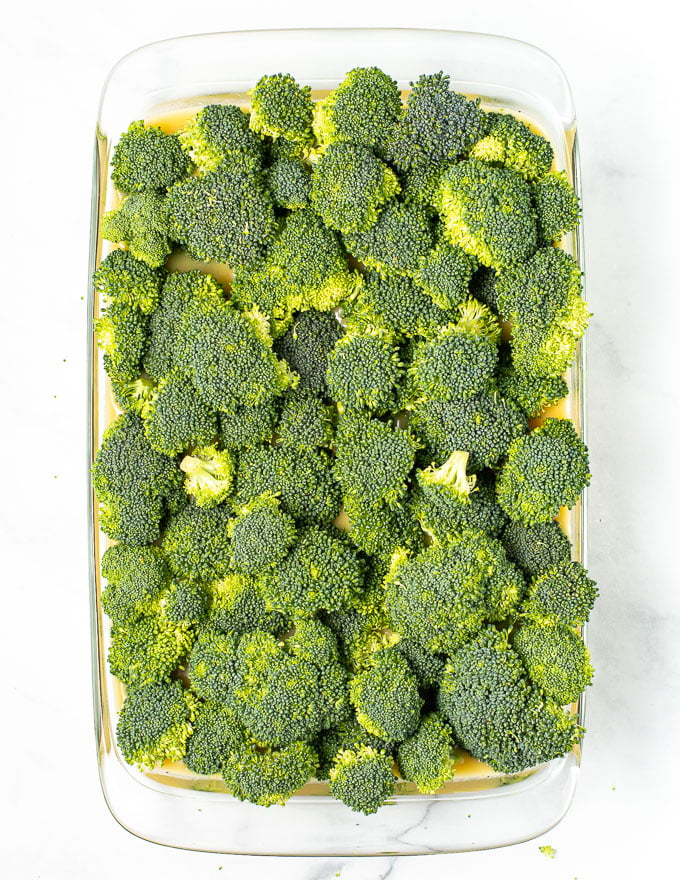 broccoli being placed on top of vegan broccoli rice casserole