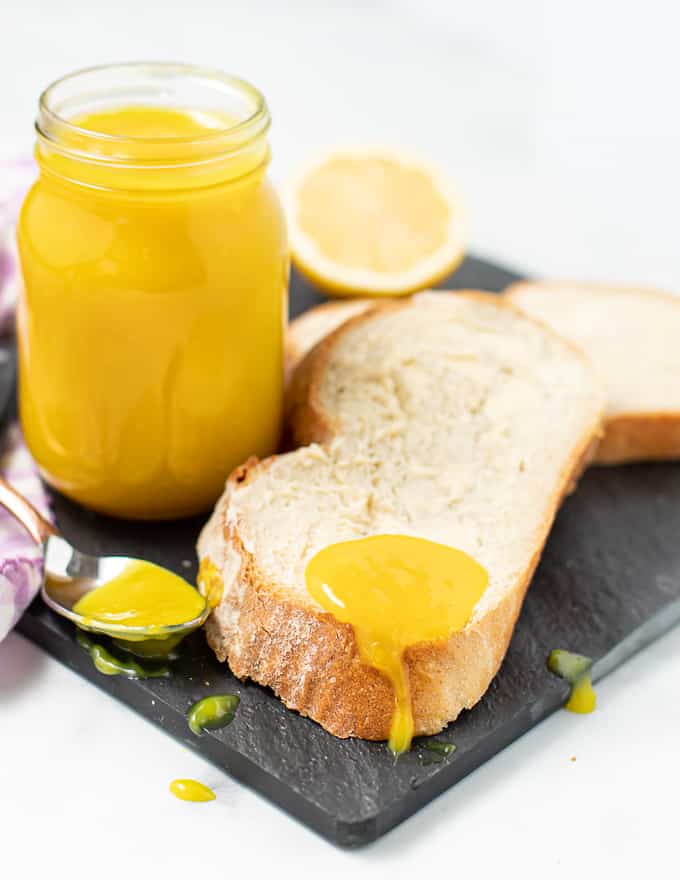 pão branco com uma colher de vegan coalhada de limão pingando-lo