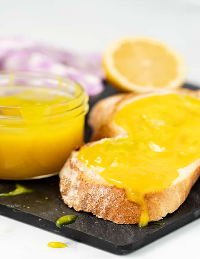 vegaaninen lemon curd levitettynä valkoisen leivän siivulle