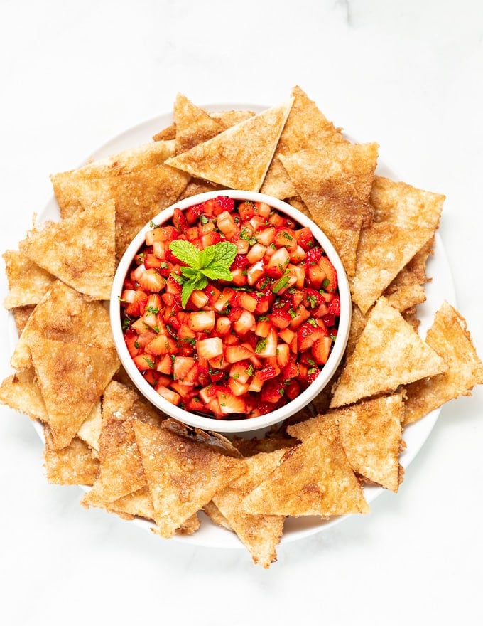 a bowl of Dessert Strawberry Salsa surrounded by cinnamon chips