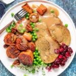 Vegan roast sliced on a plate with all the trimmings
