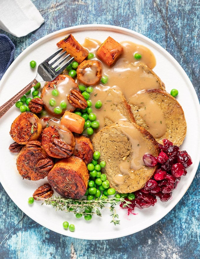  Un Rôti végétalien avec toutes les garnitures sur une assiette blanche