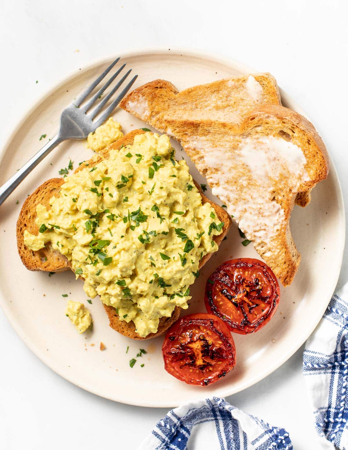 vegan scrambled eggs on toast with grilled tomatoes