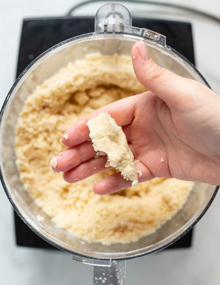 a piece of vegan shortbread dough on a persons hand