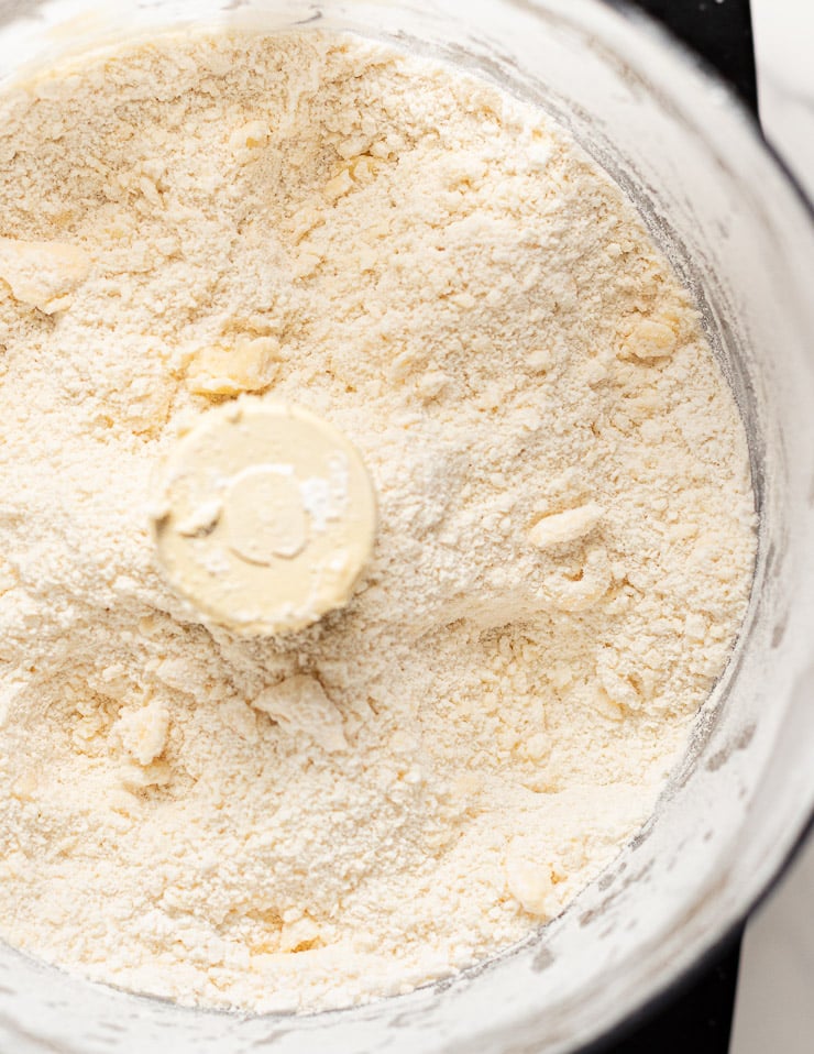 flour, salt, baking powder and vegan butter after being pulsed together in a food processor