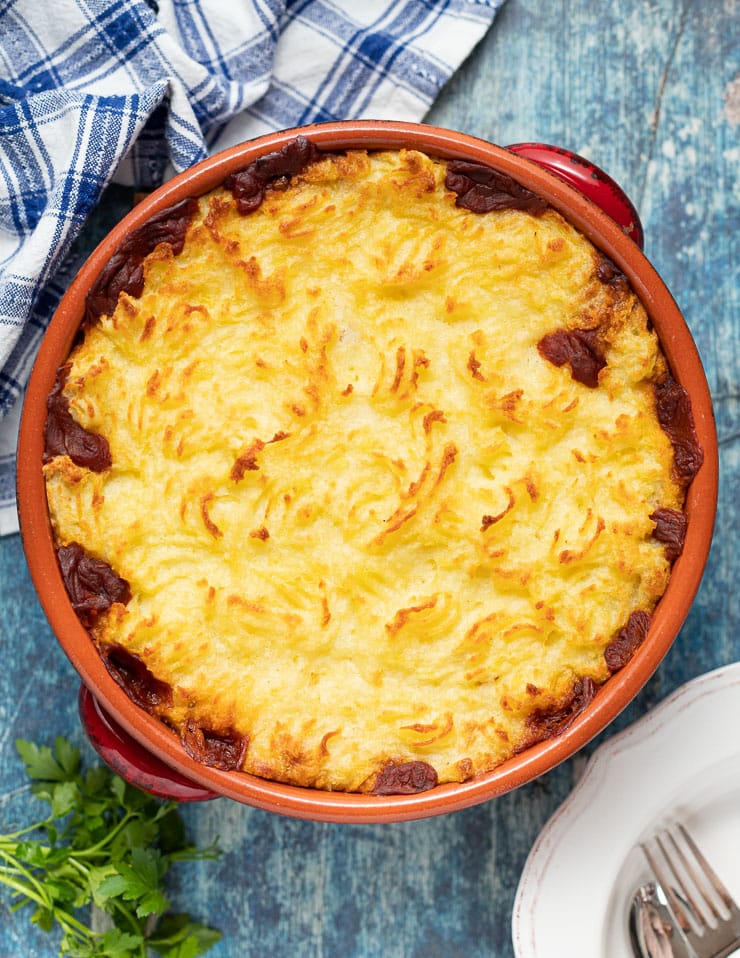 A golden Lentil Shepherd's Pie in a terracotta dish 