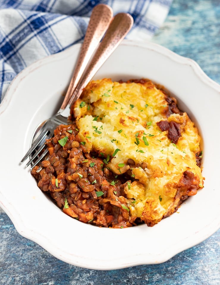 vegan shepherd's pie in a bowl, sprinkled with chopped parsley 