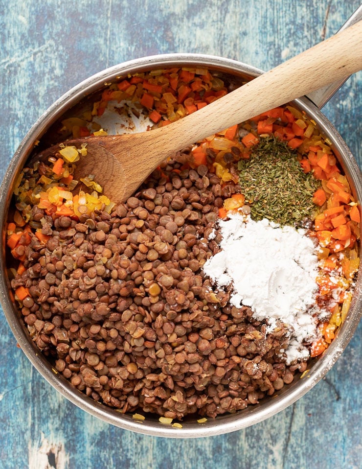 lenticchie, arrowroot, erbe, carote, cipolle e aglio in una padella