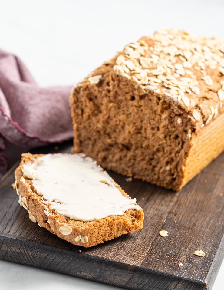 a loaf of yeast free spelt bread sliced on a board