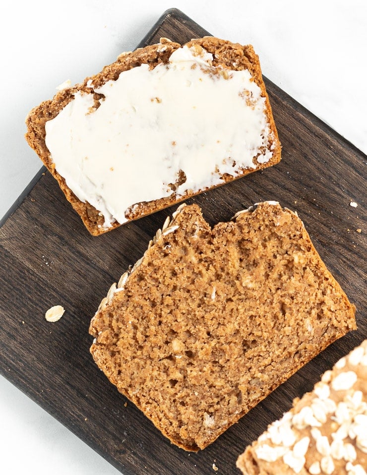 2 slices of yeast-free spelt bread on a board. One as is and one buttered