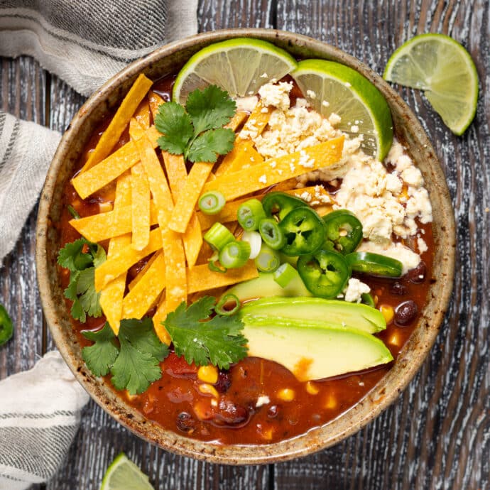a bowl of vegan tortilla soup with toppings