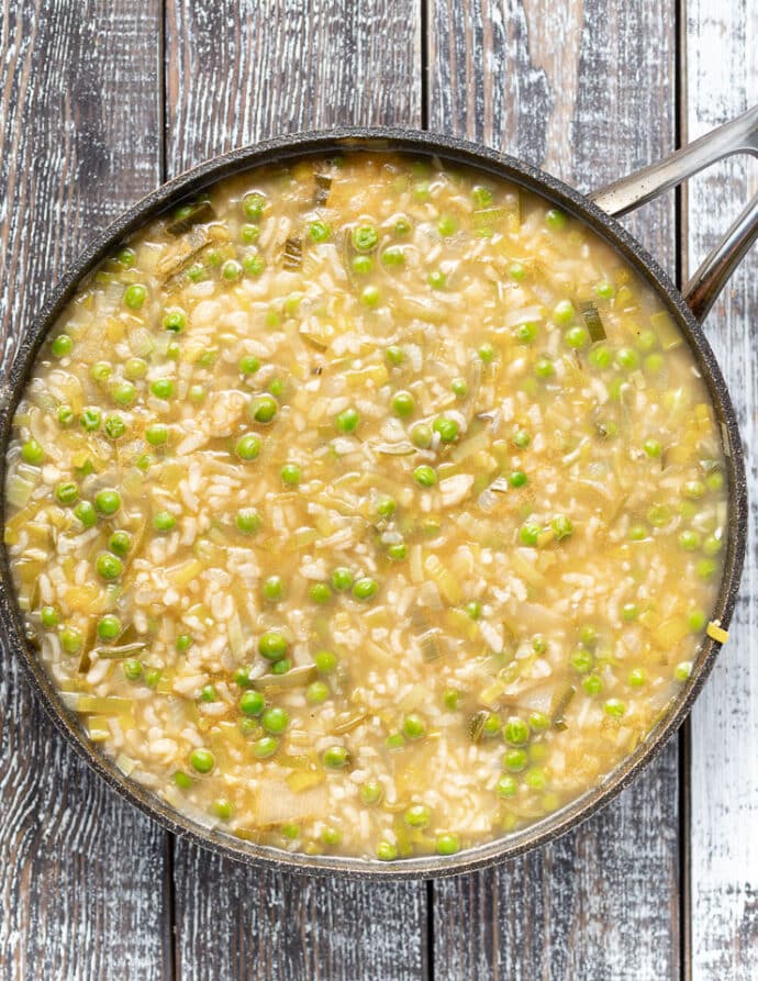 Risi e Bisi (Italian Rice and Peas) cooking in a pan