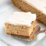 a slice of vegan banana cake being lifted out of a glass dish with a spatula