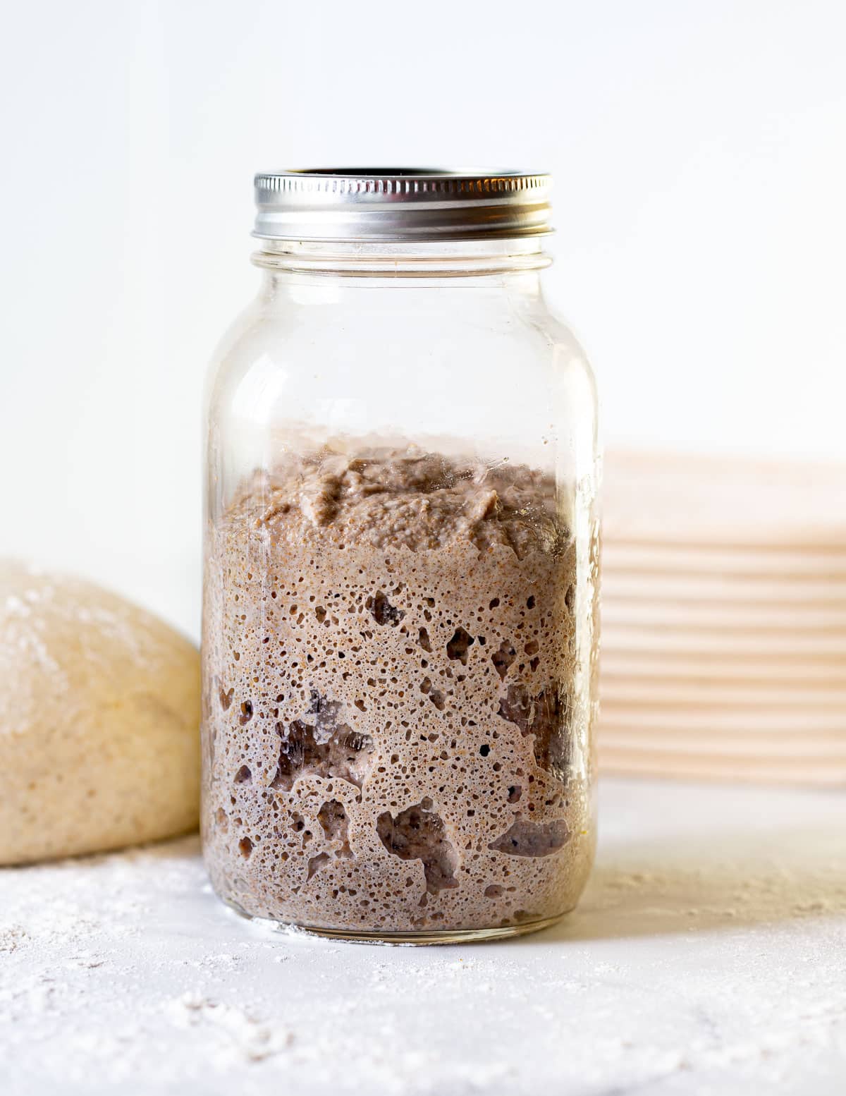 a jar of happy looking sourdough starter that's full of bubbles
