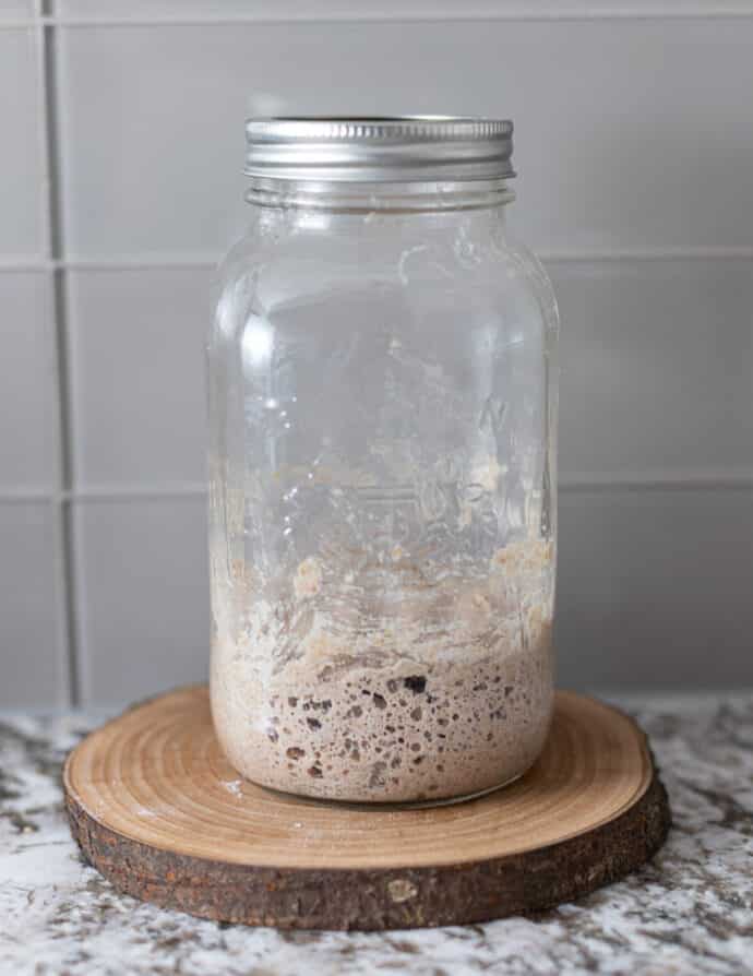 a small amount of bubbly sourdough starter in a jar