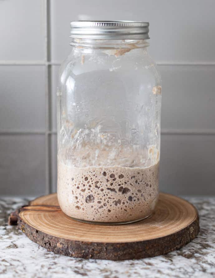 bubbly, fermented sourdough starter in a jar