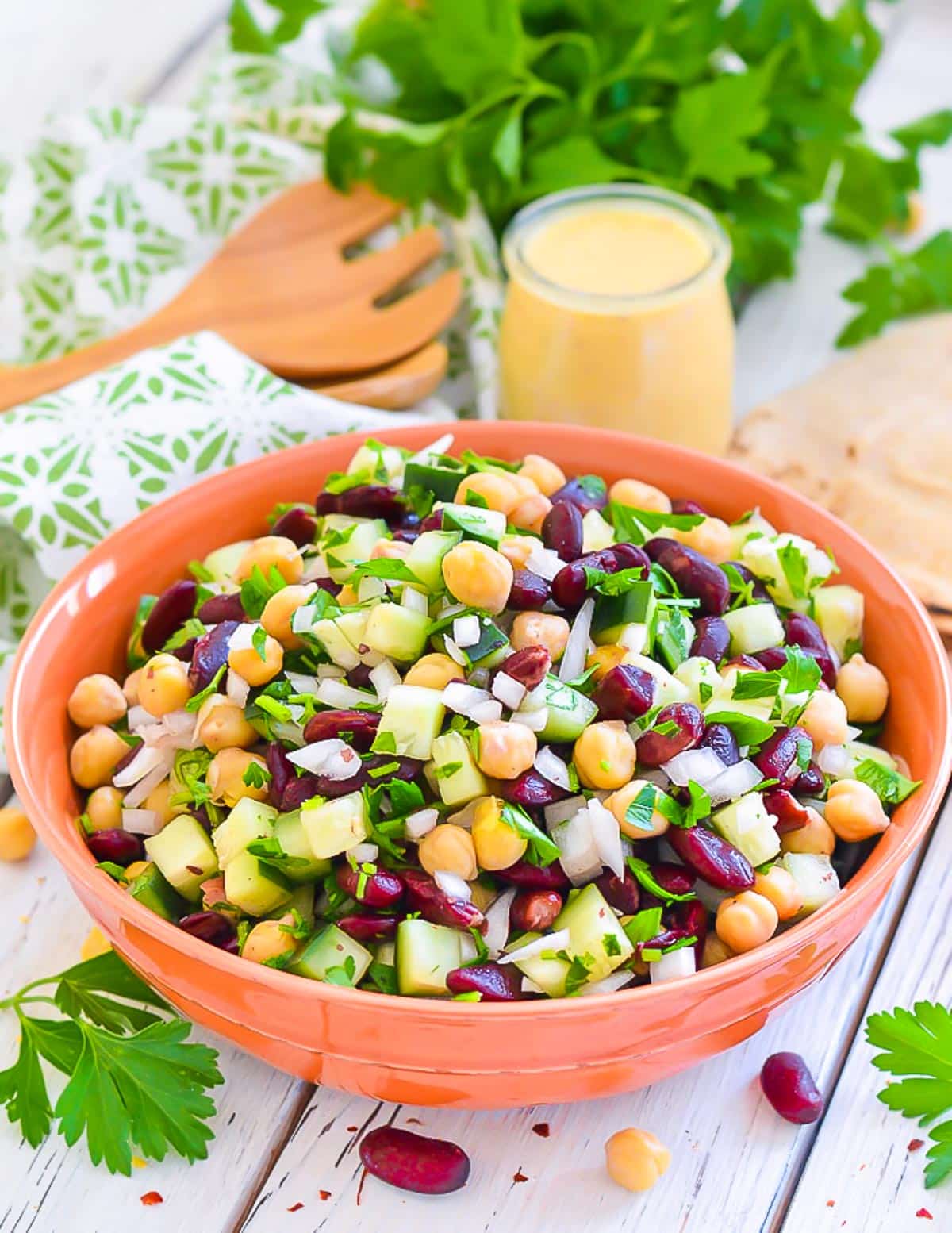 kidney bean salad in a bowl with a jar of lemon dressing behind