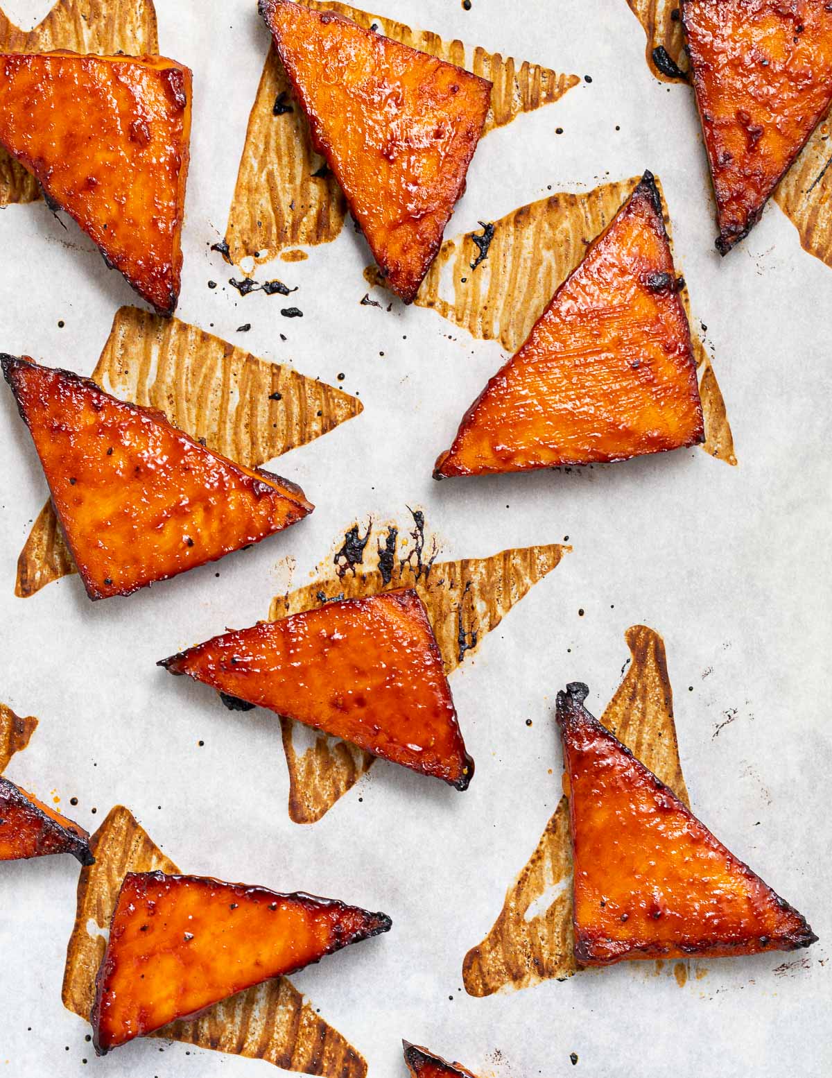 glazed and baked tofu triangles on a baking tray 