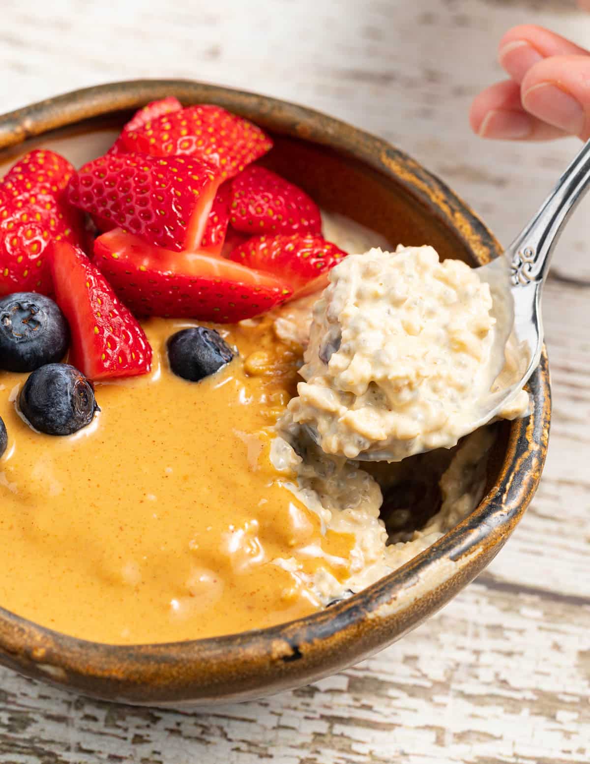 a spoon of Bircher muesli being taken from a bowl