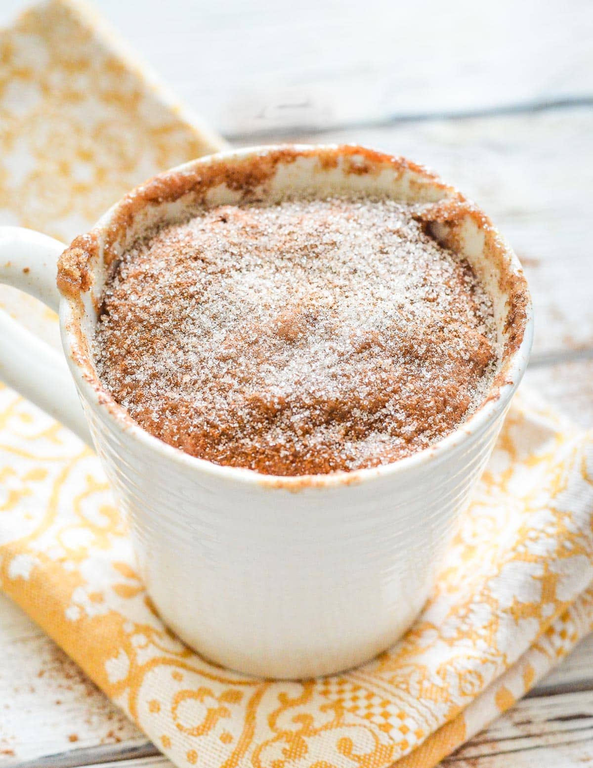 a snickerdoodle mug cake on a yellow napkin