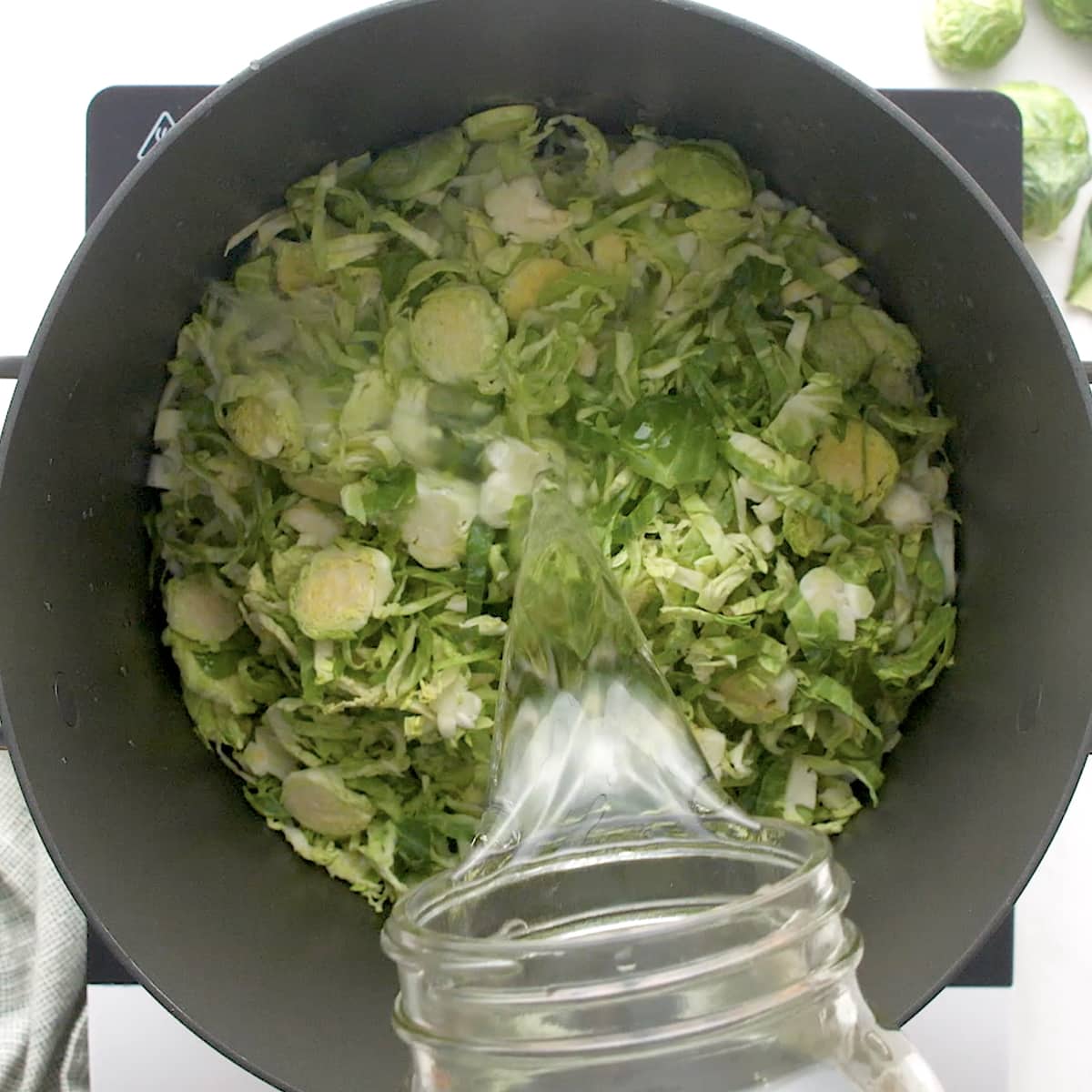 shredded brussels sprouts and cabbage in a pan with water
