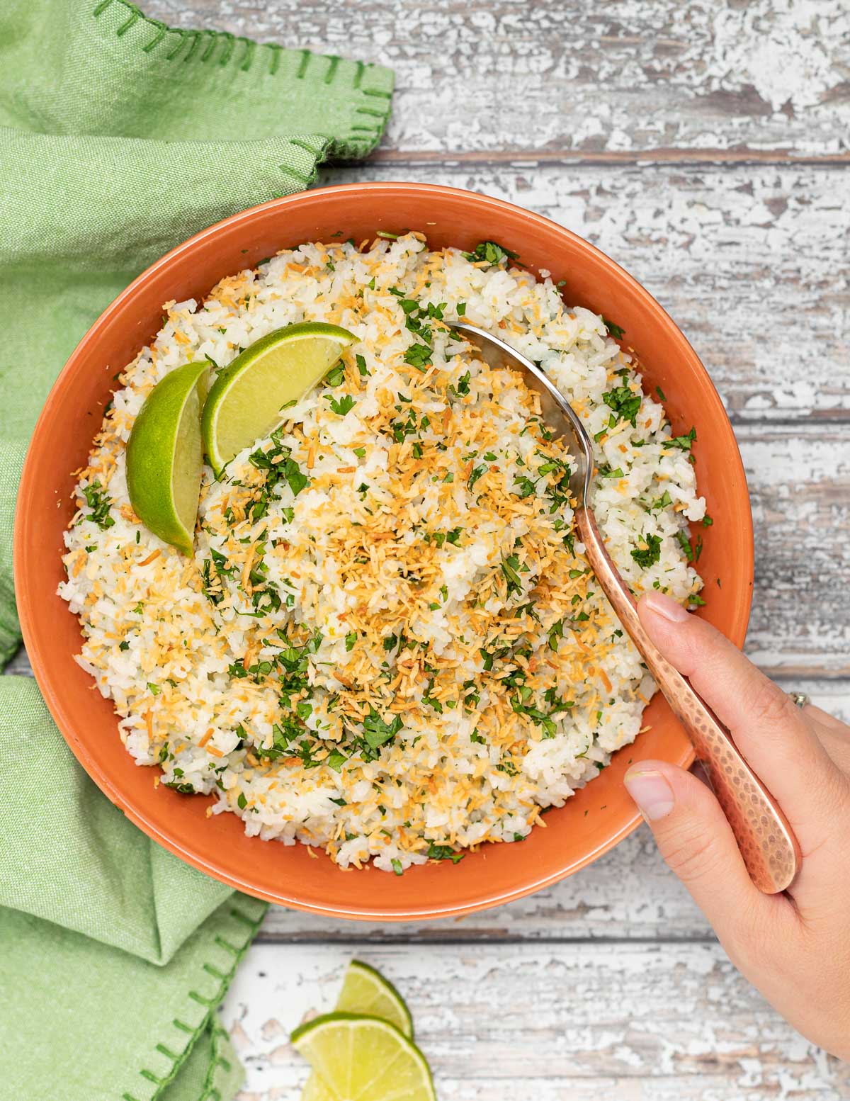 a bowl of coconut lime rice with a spoon digging into it