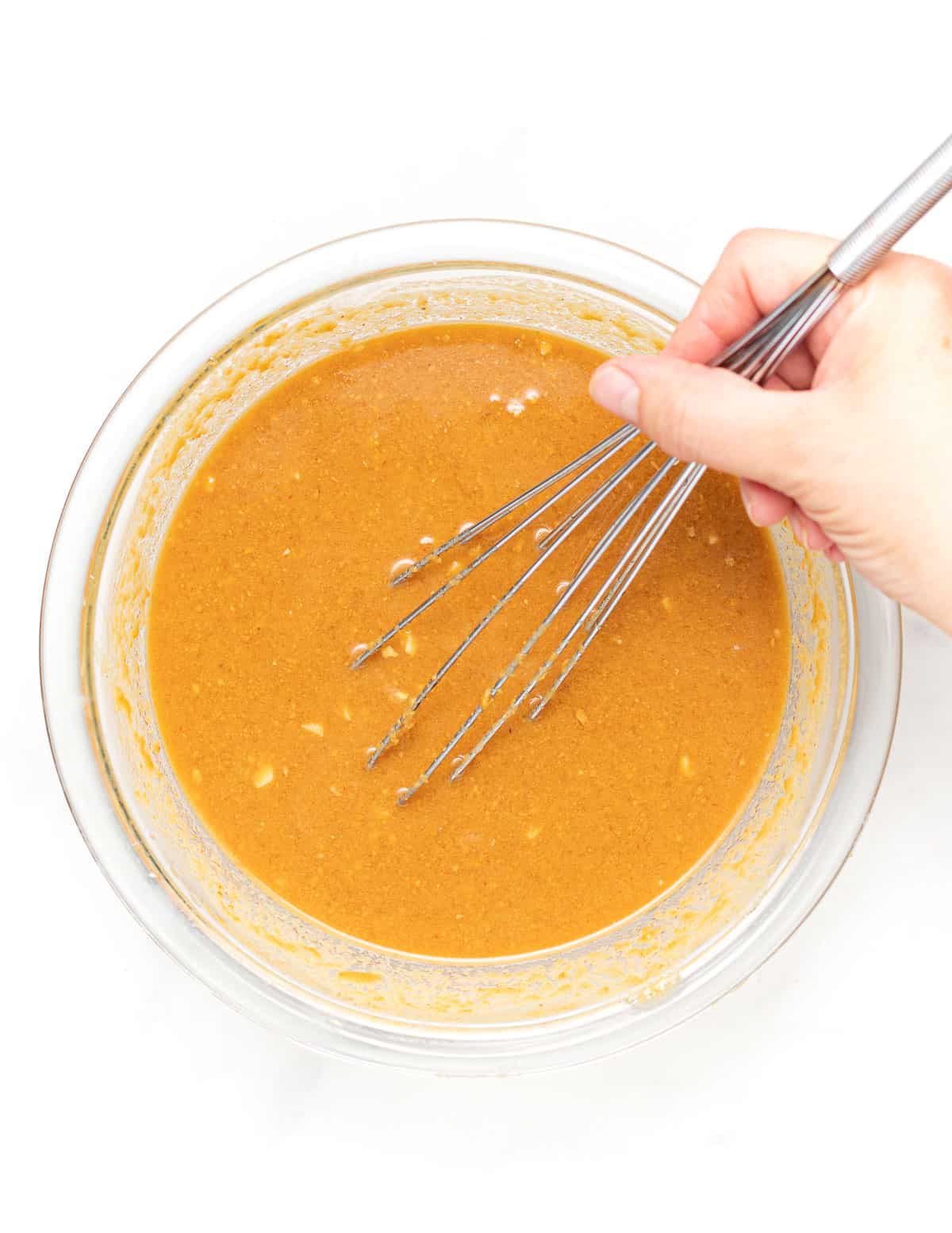 whisking sauce in a bowl