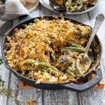 a skillet full of green bean casserole with a spoon in it