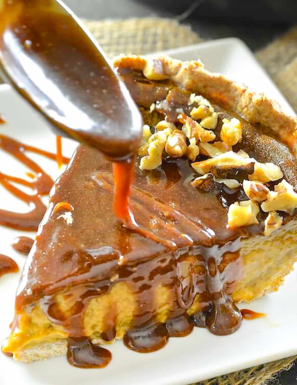 a slice of pumpkin pie being drizzled with caramel 