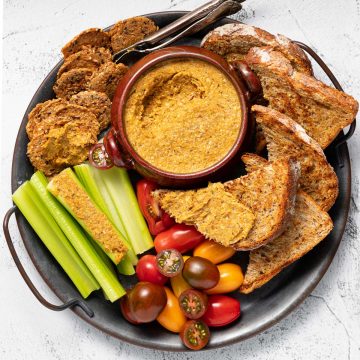 a tray of vegetable pate, toast, crackers, celery and tomatoes