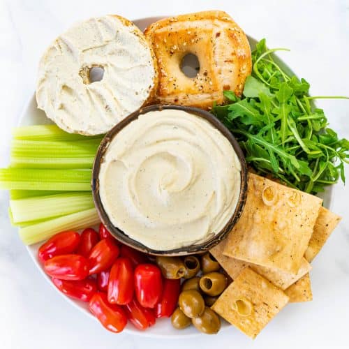 vegan cream cheese on a platter of crackers, bagels, veggies