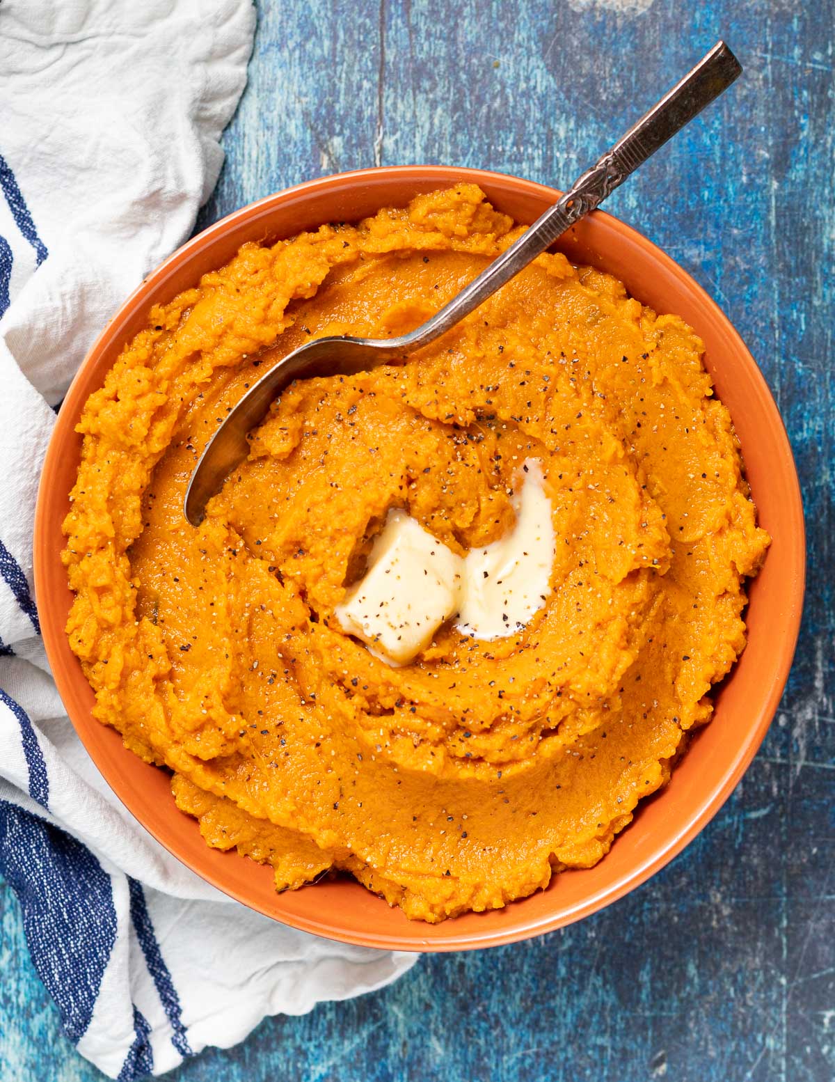 a bowl of vegan mashed sweet potatoes with some vegan butter on top