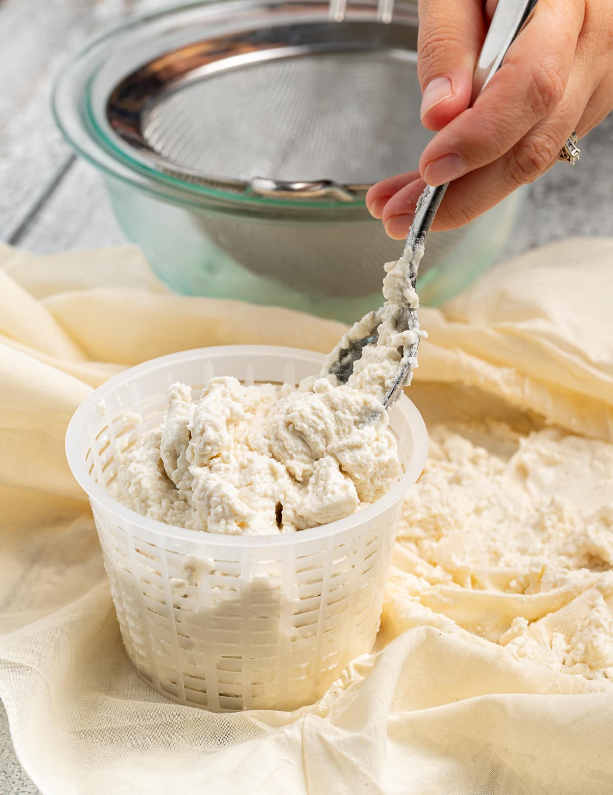 vegan ricotta being packed into a cheese mold