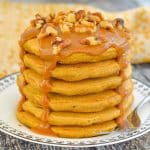 a stack of sweet potato pancakes with caramel and nuts