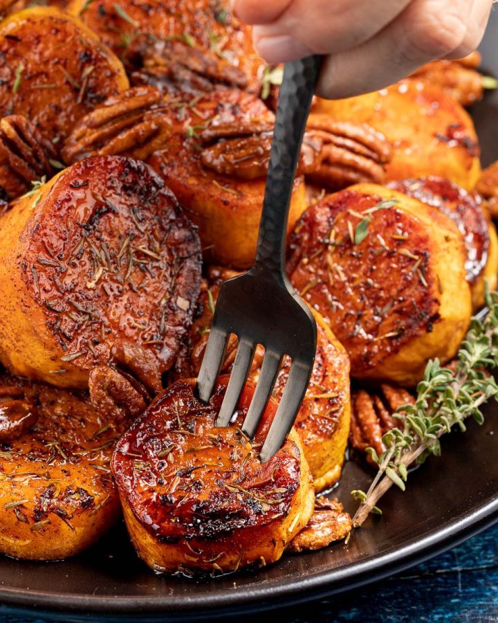 a fork being stuck into a pile of caramelized sweet potatoes