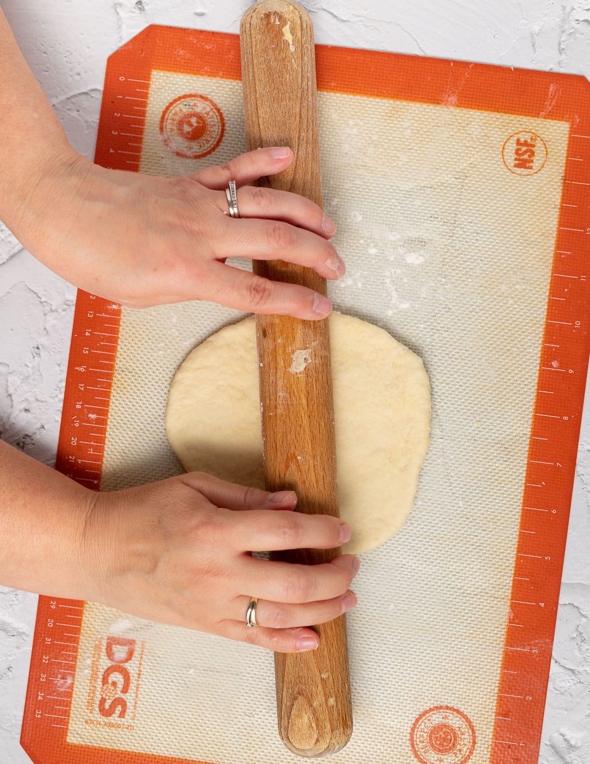 rolling a circle of dough with a rolling pin
