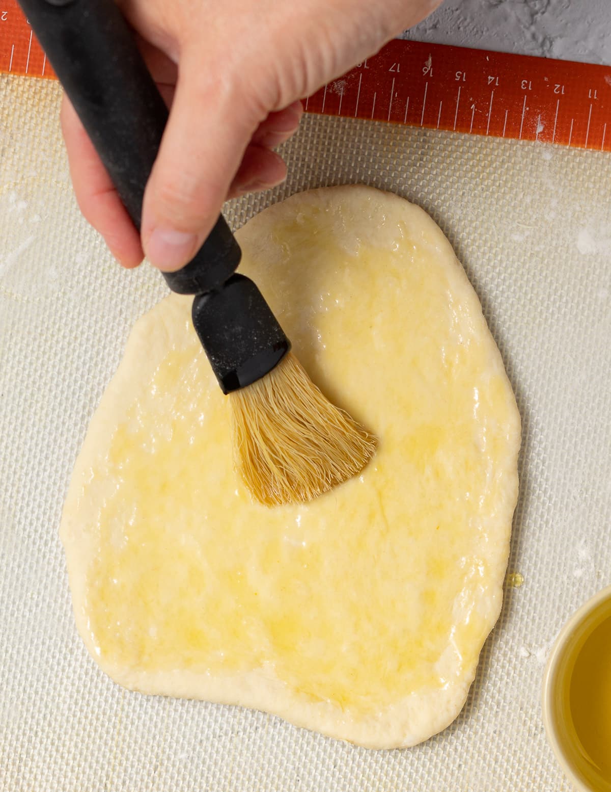 brushing uncooked flatbread with oil