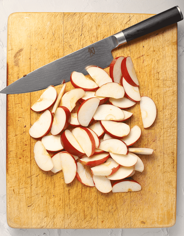 shun knife on a wooden board with some apple slices