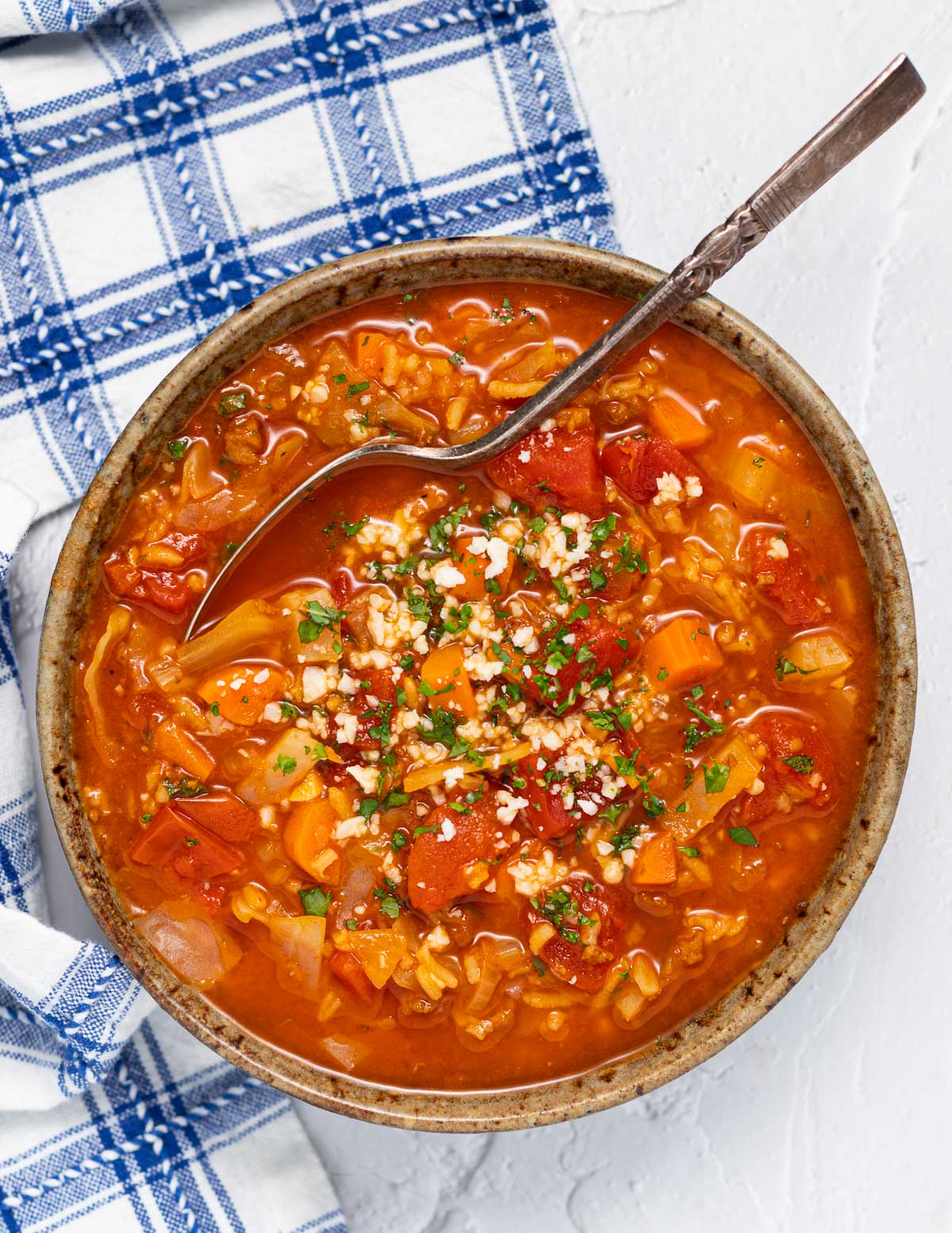 a small bowl of vegan cabbage soup with parsley and vegan cheese crumbles