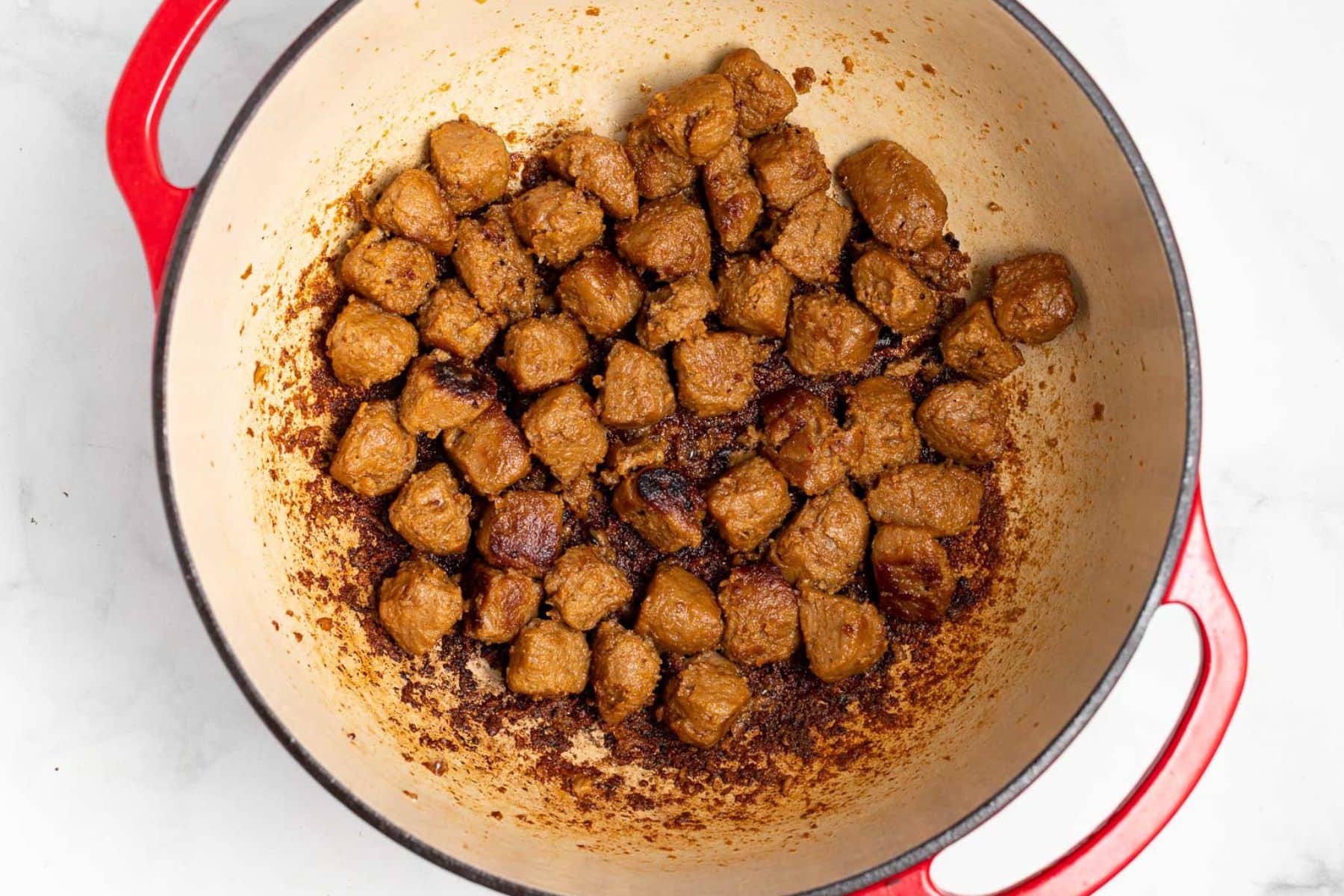 seared vegan beef chunks in a Dutch oven