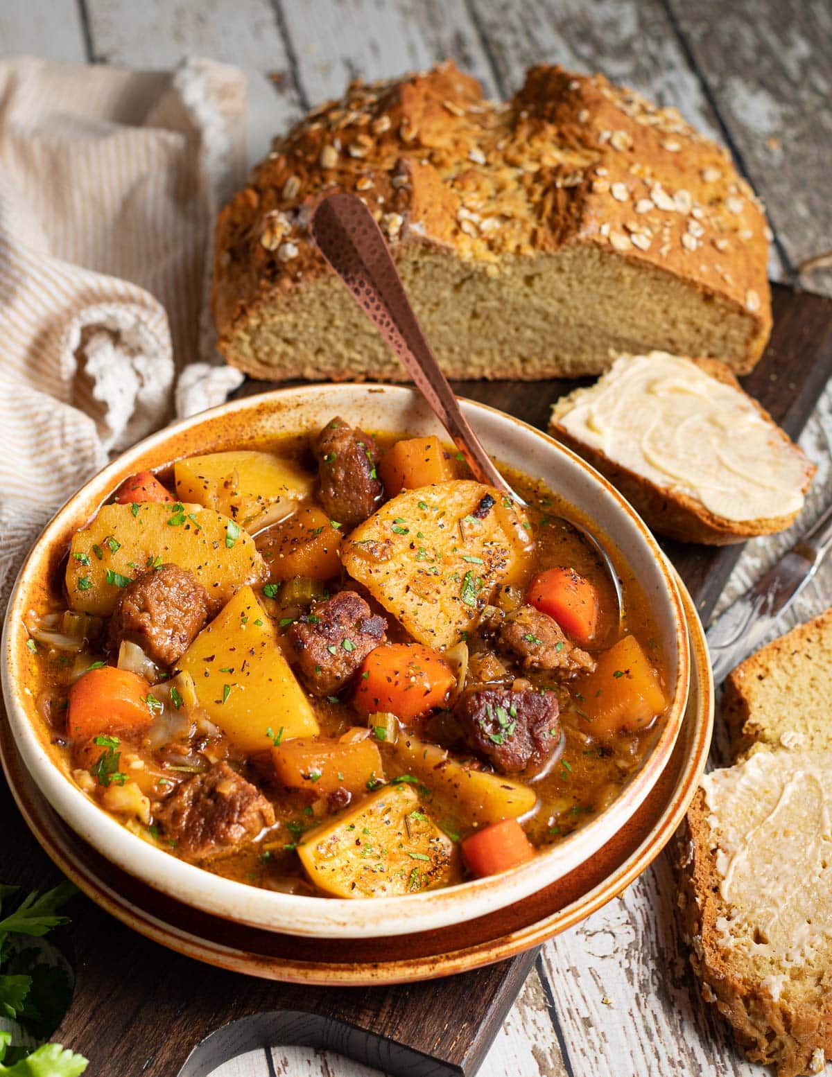 a bowl of stew next to some soda bread