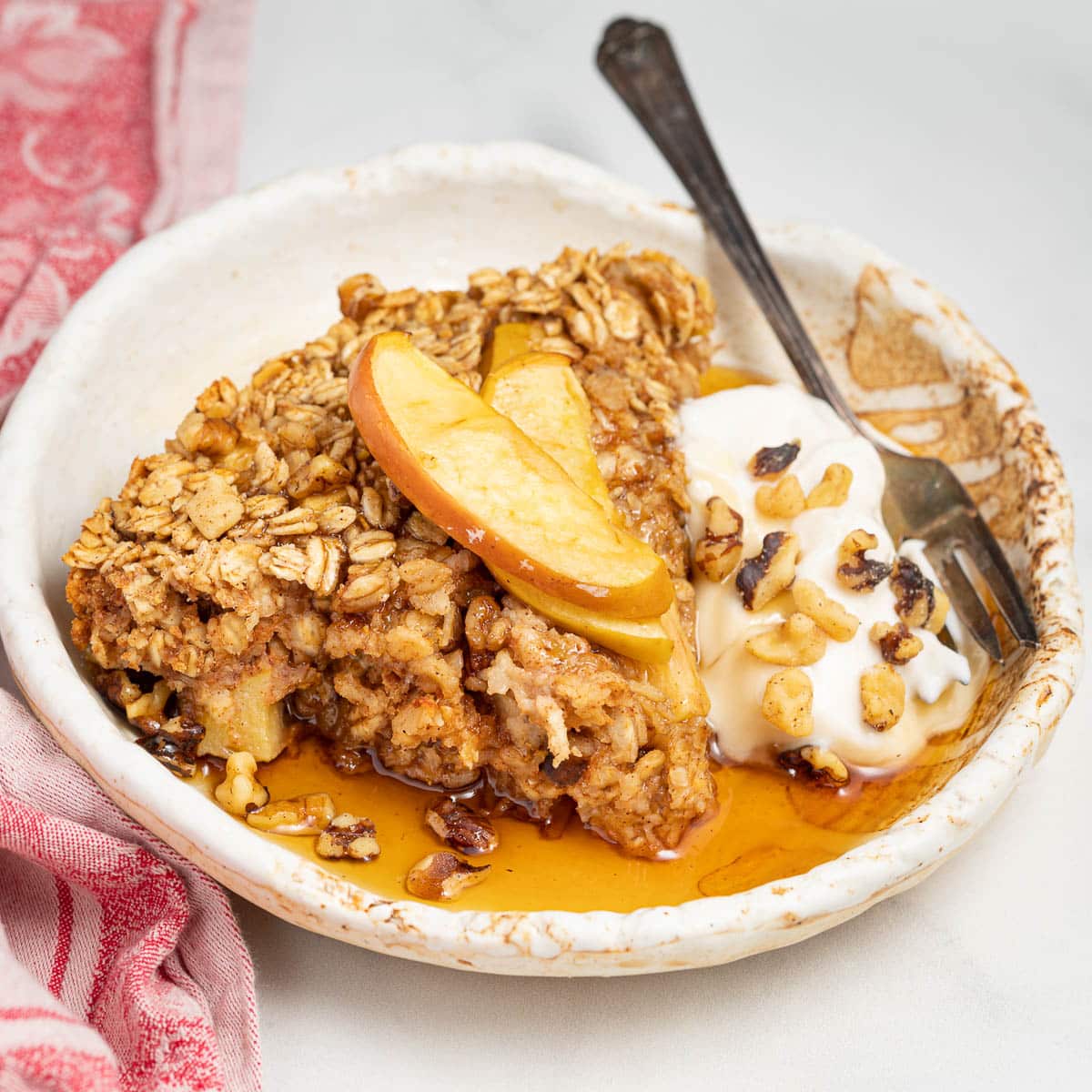 a slice of apple baked oatmeal with yogurt and maple syrup