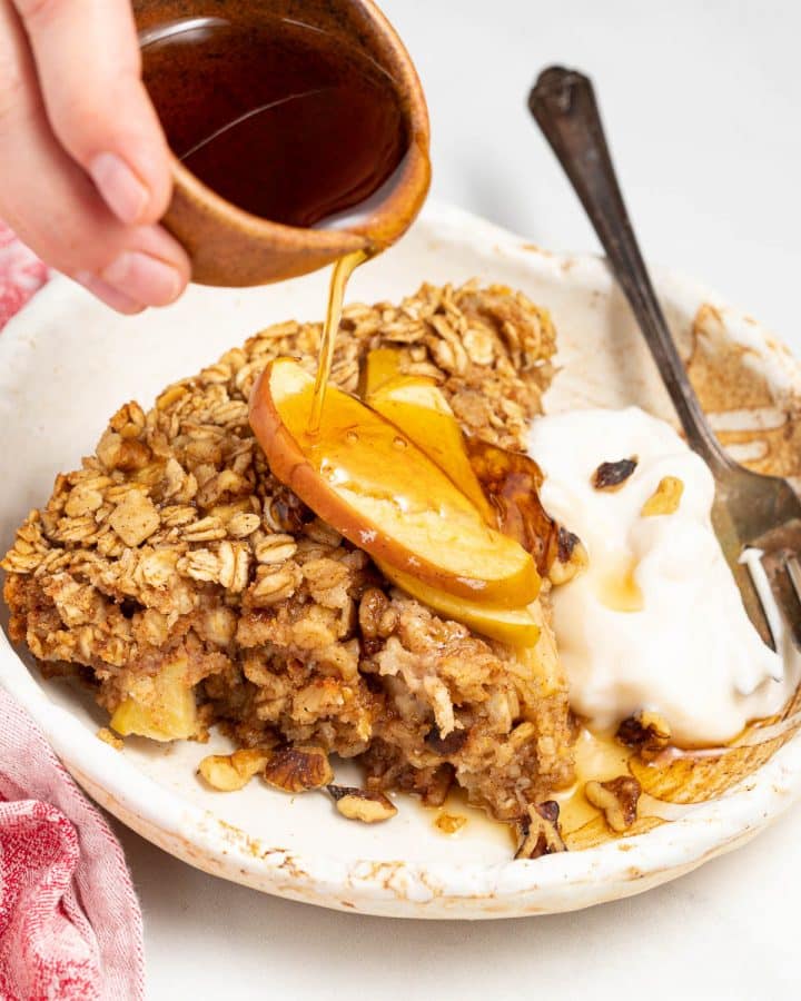 pouring syrup over apple baked oatmeal