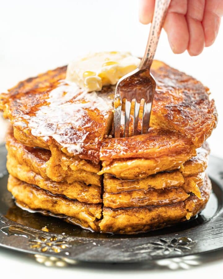 a fork going into a stack of vegan pumpkin pancakes