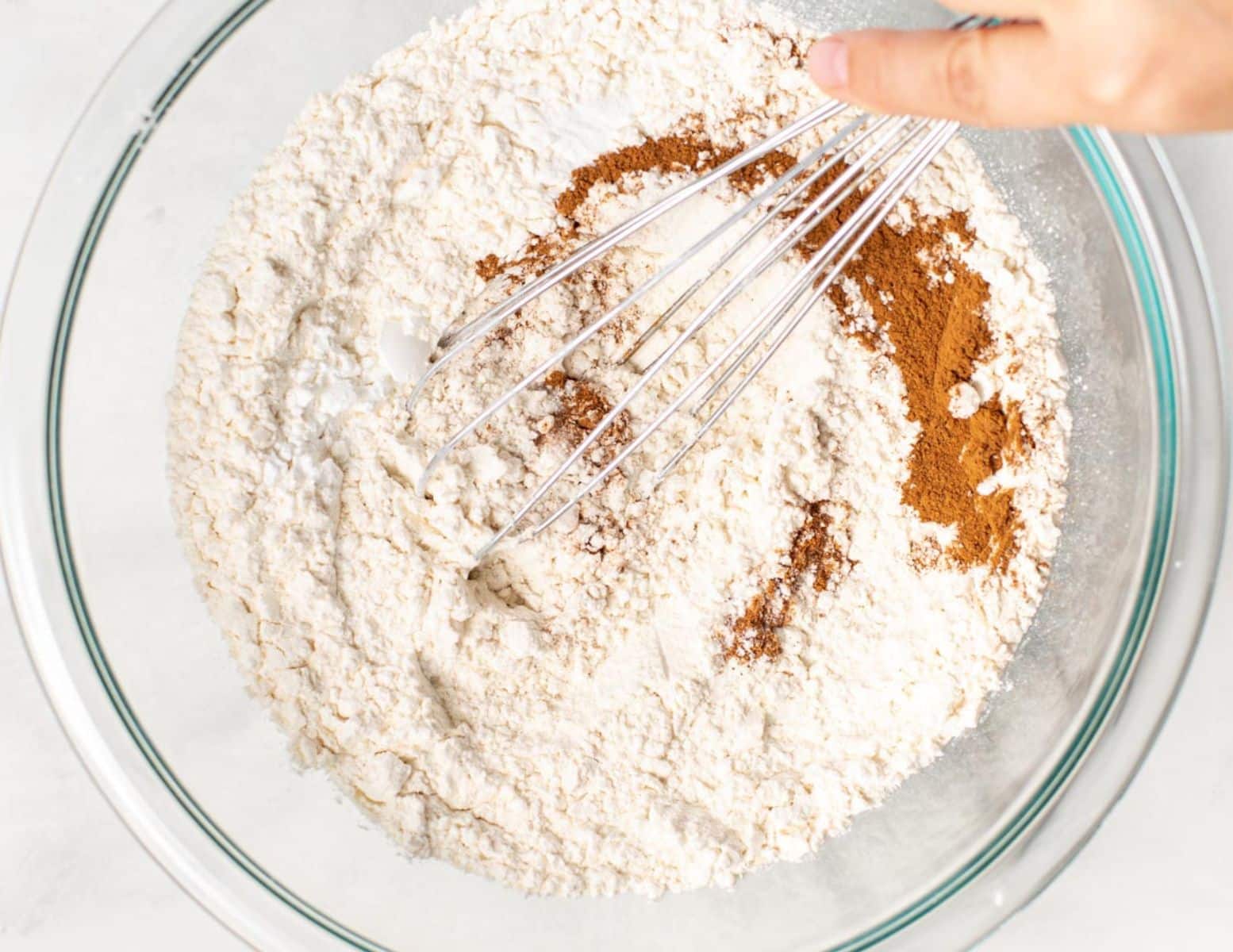 flour and spices in a bowl with a whisk