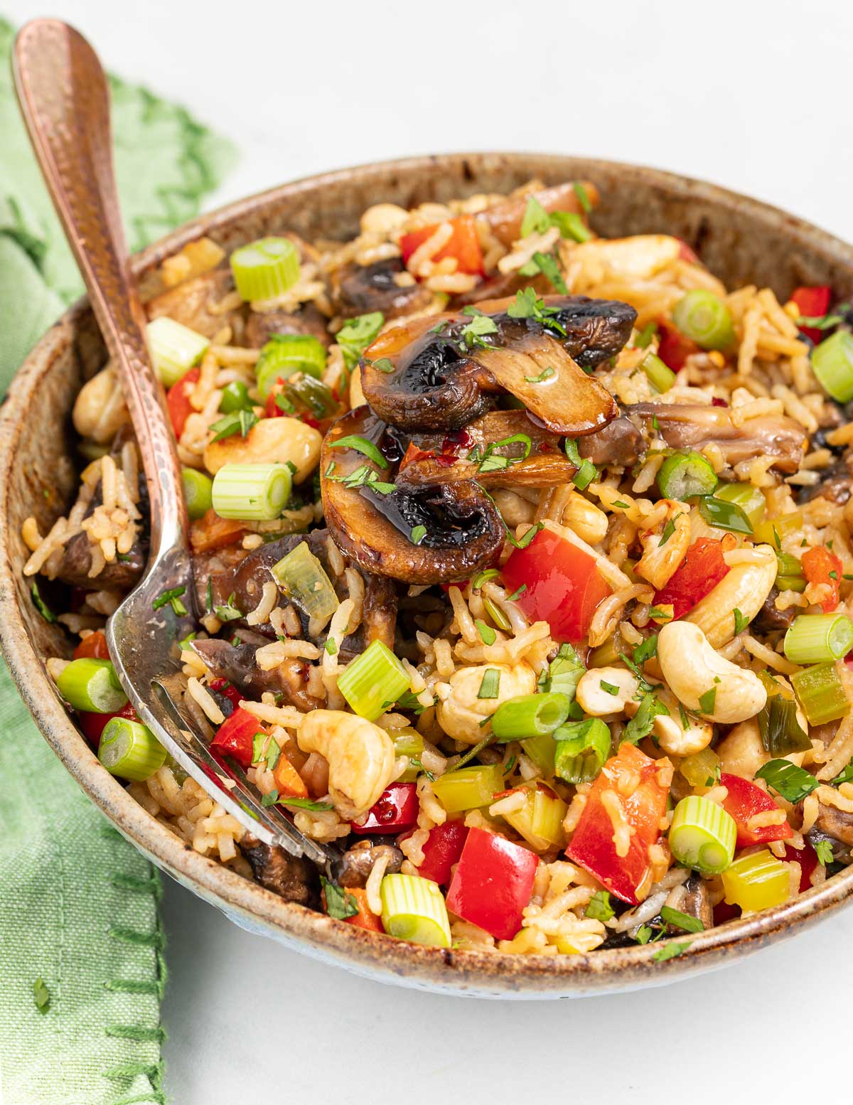 a bowl of mushroom fried rice with a fork