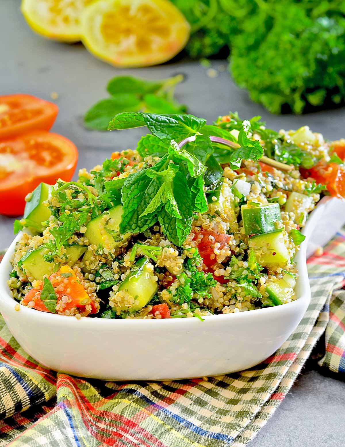 a white bowl full of gluten-free tabbouleh, garnished with mint leaves