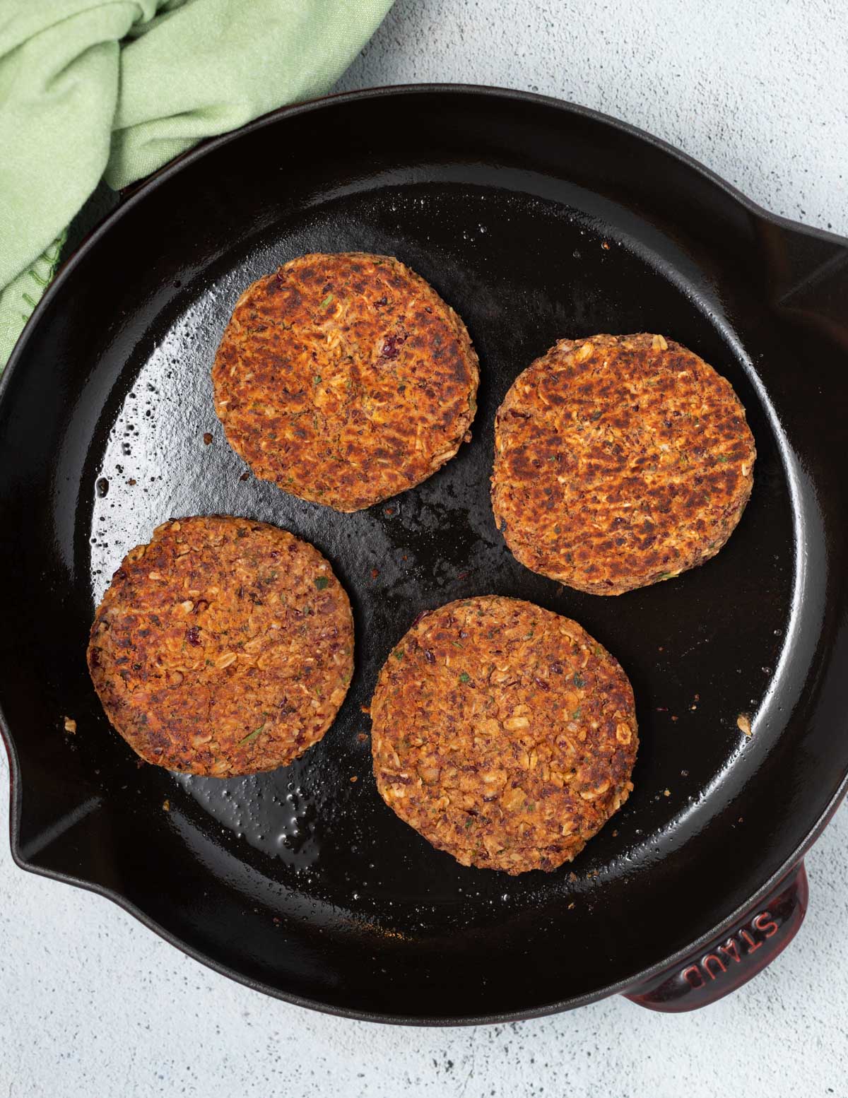 a cast iron skillet with bean burgers in it 